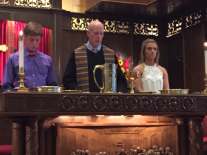 Jackson Berry and Hailey Hunter serve at the communion table with Dr. Miles